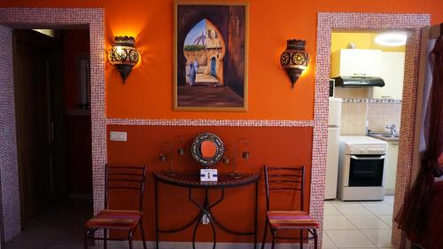 布鲁塞尔巴拉迷笛公寓式酒店的厨房配有带桌椅的橙色墙壁