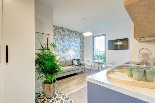 格但斯克Tropical Islands - Apartamenty przy Plaży的厨房以及带沙发和桌子的客厅。
