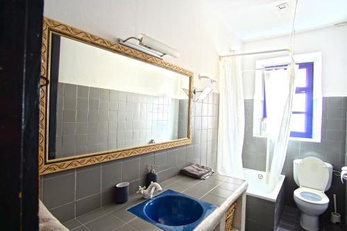 赫罗纳La Lleona Apartment的浴室设有蓝色水槽和镜子