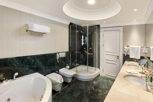 塔什干温德姆塔什干酒店的带浴缸、卫生间和盥洗盆的浴室