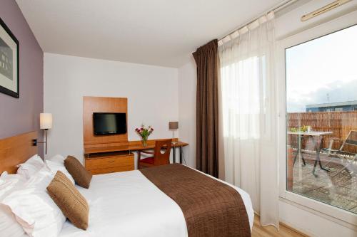 鲁昂公园和套房鲁昂诺曼底酒店的酒店客房设有一张床和一个大窗户