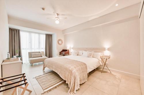 大加那利岛拉斯帕尔马斯Maresía Canteras Urban Hotel的白色卧室配有一张大床和椅子