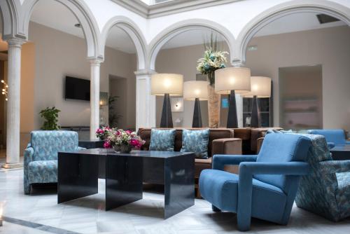 塞维利亚珀蒂宫马克斯圣安娜高科技酒店的客厅配有蓝色的椅子和桌子