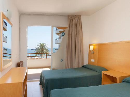 伊维萨镇大海与沙滩公寓的酒店客房设有两张床和一个阳台。
