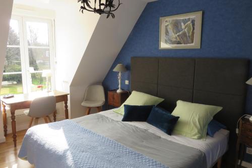 阿斯克新城阿拉梅松都合容酒店的一间卧室配有一张带蓝色墙壁的大床