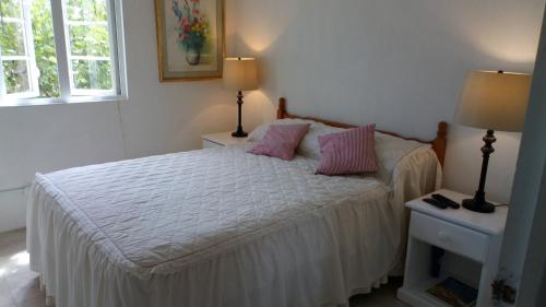 圣菲利普The Pool House的一间卧室配有带粉红色枕头的床。