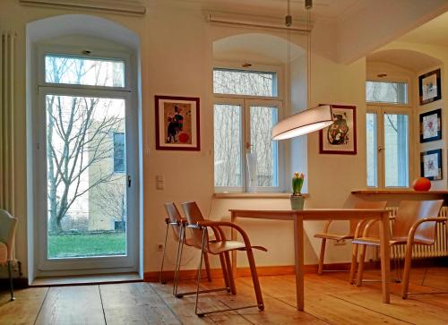 德累斯顿Neustadt - Paradies的一间带桌椅和窗户的用餐室