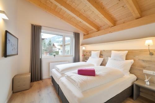 圣安东阿尔贝格Schlosskopf Suiten的一间卧室配有一张大床,上面有粉红色枕头