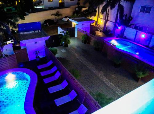 科托努Hotel Les Orchidées的紫色灯光的游泳池顶部景观