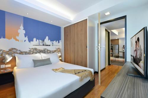 曼谷Citadines Sukhumvit 11 Bangkok的一间带白色大床的卧室和一间客厅
