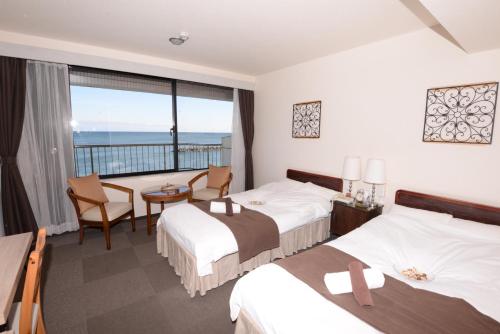 Isohara磯原海边酒店的酒店客房设有两张床和一个阳台。