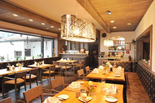 贝尔恩里德Bernrieder Hof的餐厅设有木桌、椅子和吊灯。