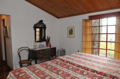 Santa Cruz do DouroCasa do Silvério的一间卧室配有一张床、一个梳妆台和一扇窗户。