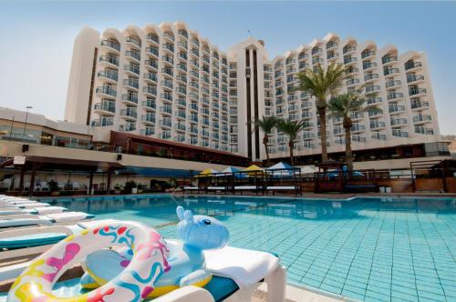 提比里亚莱昂纳多俱乐部提比利亚全包型酒店的酒店游泳池的背景是一座大型建筑