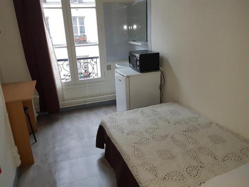 巴黎玛德皇家酒店的小房间设有一张床和一台冰箱