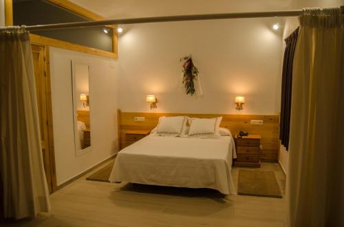 BoceguillasHotel Las Casitas的卧室配有白色的床和镜子