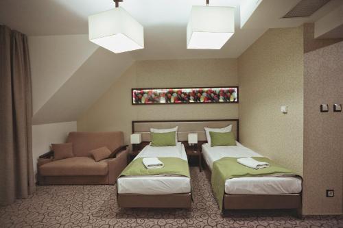 卢布林地区亚努夫Hotel Janów的酒店客房,设有两张床和一张沙发