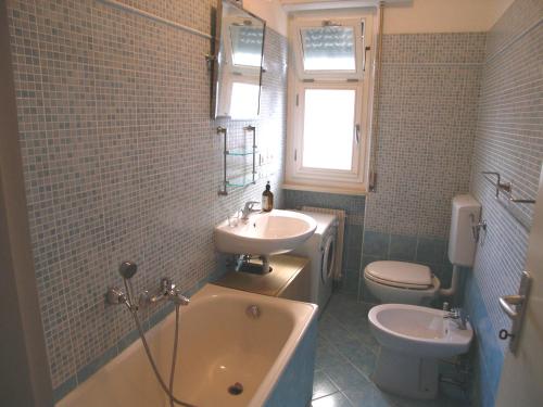 格拉多Appartamento Dionea的带浴缸、盥洗盆和卫生间的浴室