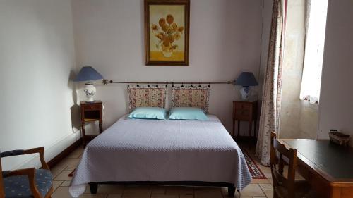 Champagné-les-Marais克洛泽拉酒店的一间卧室配有一张带蓝色枕头的床。