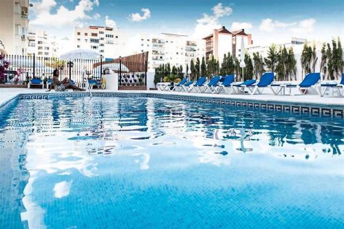 马贝拉埃尔法罗马贝拉酒店的一座带蓝色椅子的大型游泳池,