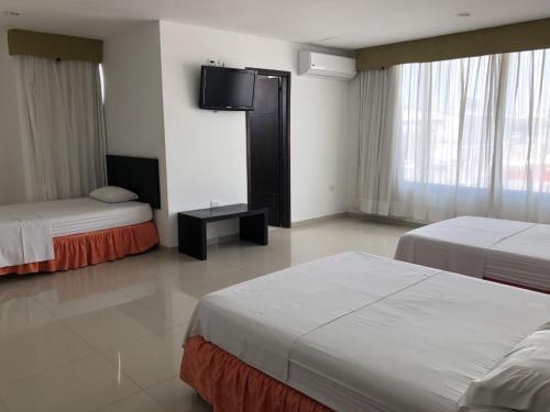 巴兰基亚Hotel Via 40的酒店客房设有两张床和一台平面电视。