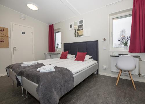 默恩达尔默恩达尔埃肯酒店的一间卧室配有一张带红色枕头的大床