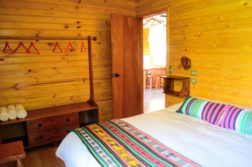 马拉卡韦罗Cabañas Techo Azul的小木屋内一间卧室,配有一张床