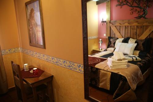 拉斯卡弗里亚Apartamentos Rurales "La Cabaña"的一张床位和一张桌子,镜子里