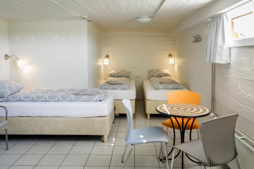 雷克侯拉尔瑞克号拉旅舍的一间设有两张床和一张桌子及椅子的房间