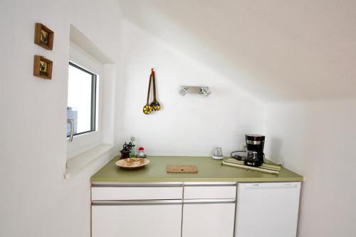 因斯布鲁克Ferienwohnung Monika Knoflach的厨房设有绿色的柜台和窗户。