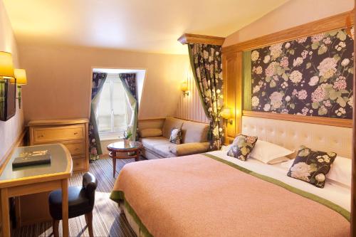 巴黎贝尔纳酒店的配有一张床和一张书桌的酒店客房