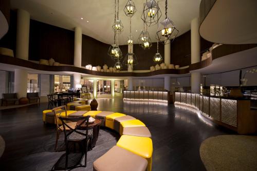金巴兰巴厘岛百丽宫度假酒店的酒吧设有黄色和白色长凳和桌子