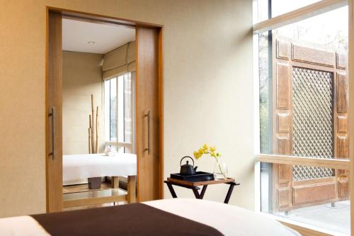 门多萨门多萨柏悦水疗赌场酒店的一间卧室配有镜子、一张床和一个窗户