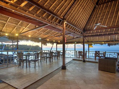 蓝梦岛Mushroom Beach Bungalows的一间带桌椅并享有水景的餐厅