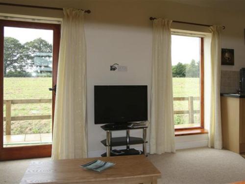 约克Lodge Cottage的客厅配有平面电视和窗户。