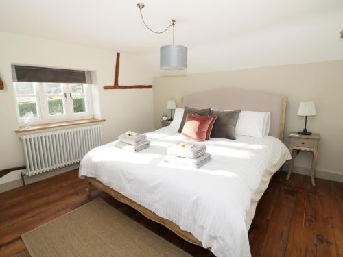 大莫尔文Ivy Cottage的卧室配有白色床和毛巾