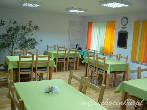 切霍齐内克Centrum wypoczynku的用餐室配有绿色桌子和木椅