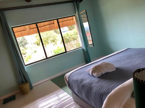 基加利皮里皮利精品酒店 的一间卧室设有一张床和两个窗户。