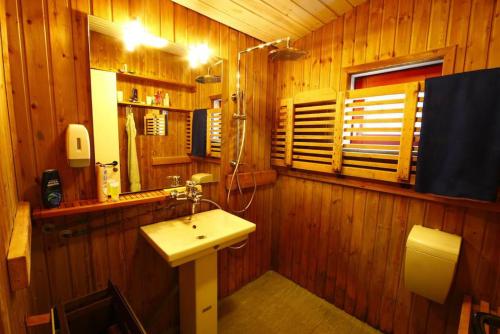 塔斯拉克红房子乡村旅馆的木制浴室设有水槽和窗户