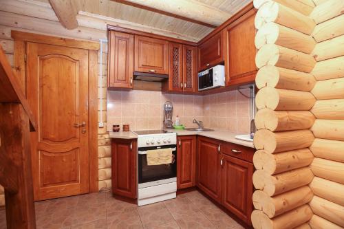亚列姆切Cottage Goyra的厨房配有木制橱柜和炉灶烤箱。