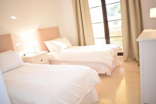 贝纳阿维斯Jardin Vista Las Jacarandas的酒店客房设有两张床和窗户。