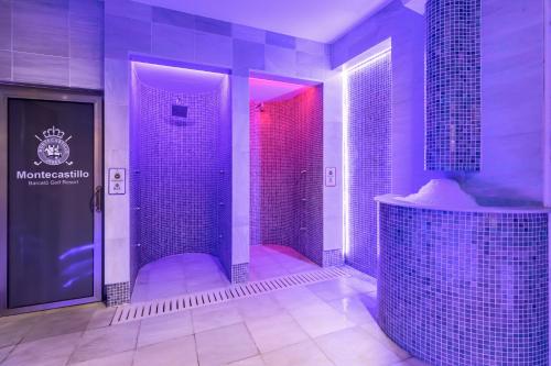 赫雷斯-德拉弗龙特拉巴瑟罗蒙蒂卡斯提罗高尔夫酒店的大型浴室设有紫色照明淋浴