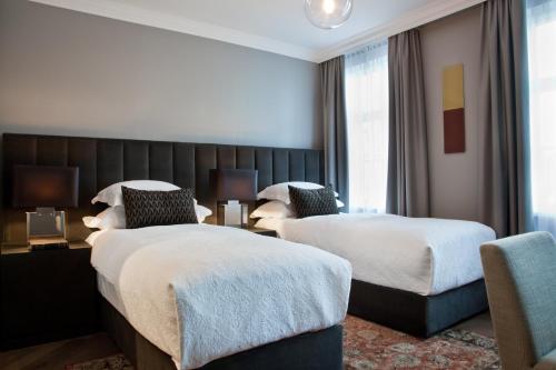 雷克雅未克Sand Hotel by Keahotels的酒店客房,配有两张床和椅子