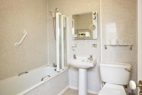 尚克林The Grange B&B的浴室配有盥洗盆、卫生间和浴缸。