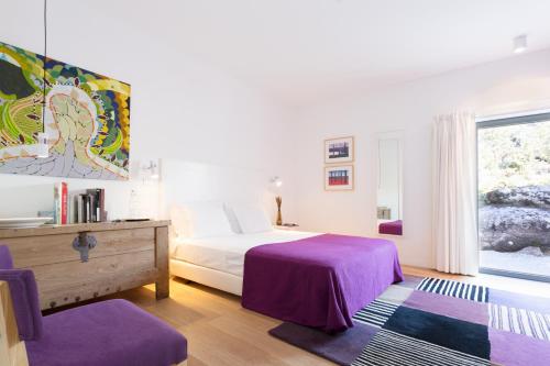 维迪堡金塔拉湾达斯酒店的一间卧室配有一张带紫色床单的床和窗户。