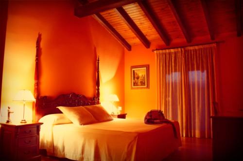 Collado阿尔科德尔罗布莱酒店的一间卧室配有一张橙色墙壁的床