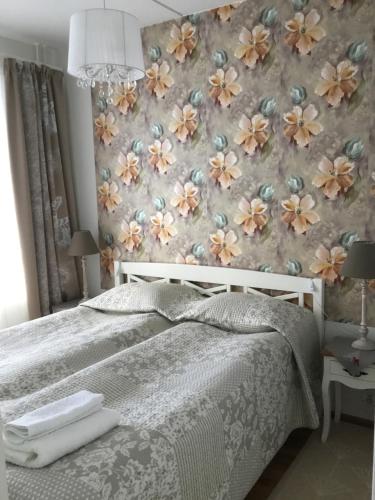 劳卡Finnclub Voyage Luxury Appartment的一间卧室配有一张带花卉壁纸的床