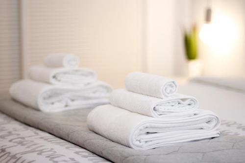 EsteponaApartment Design Marbella的浴室柜台上摆放着一堆白色毛巾