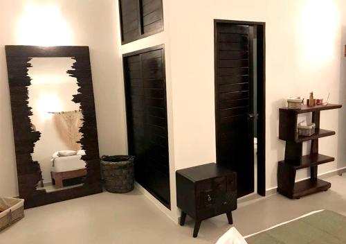 ChemuyilXcacel Dreams的一间设有黑色门、桌子和镜子的房间