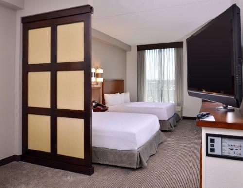 加登城凯悦广场花园城市酒店的酒店客房设有两张床和一台平面电视。